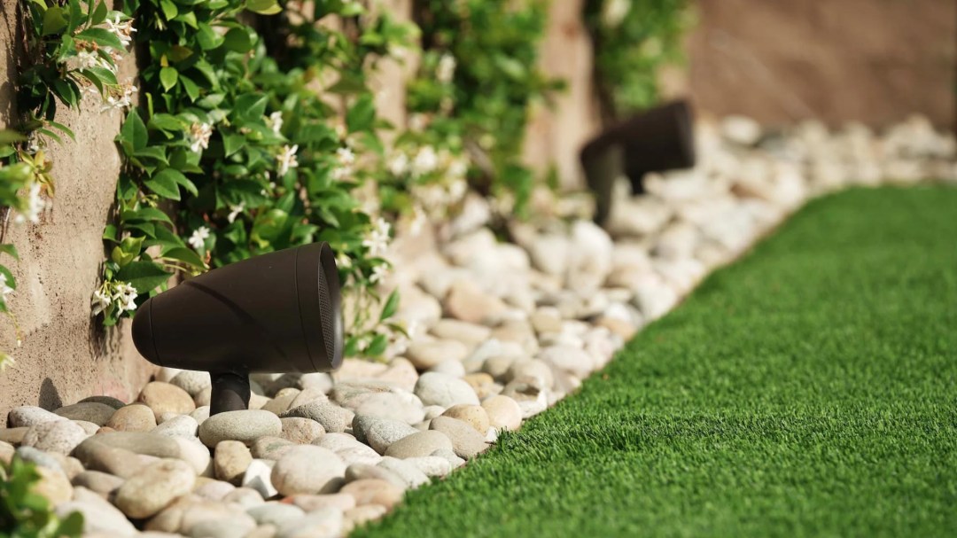 Artificial turf installed in a garden, illuminated by night vision lighting from Night Vision Lighting & Electric.