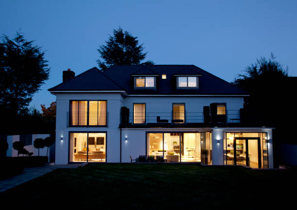 istockphoto-166272390-612x612-1 A modern house illuminated at night, showcasing bright lights, with a focus on Night Vision Lighting & Electric.